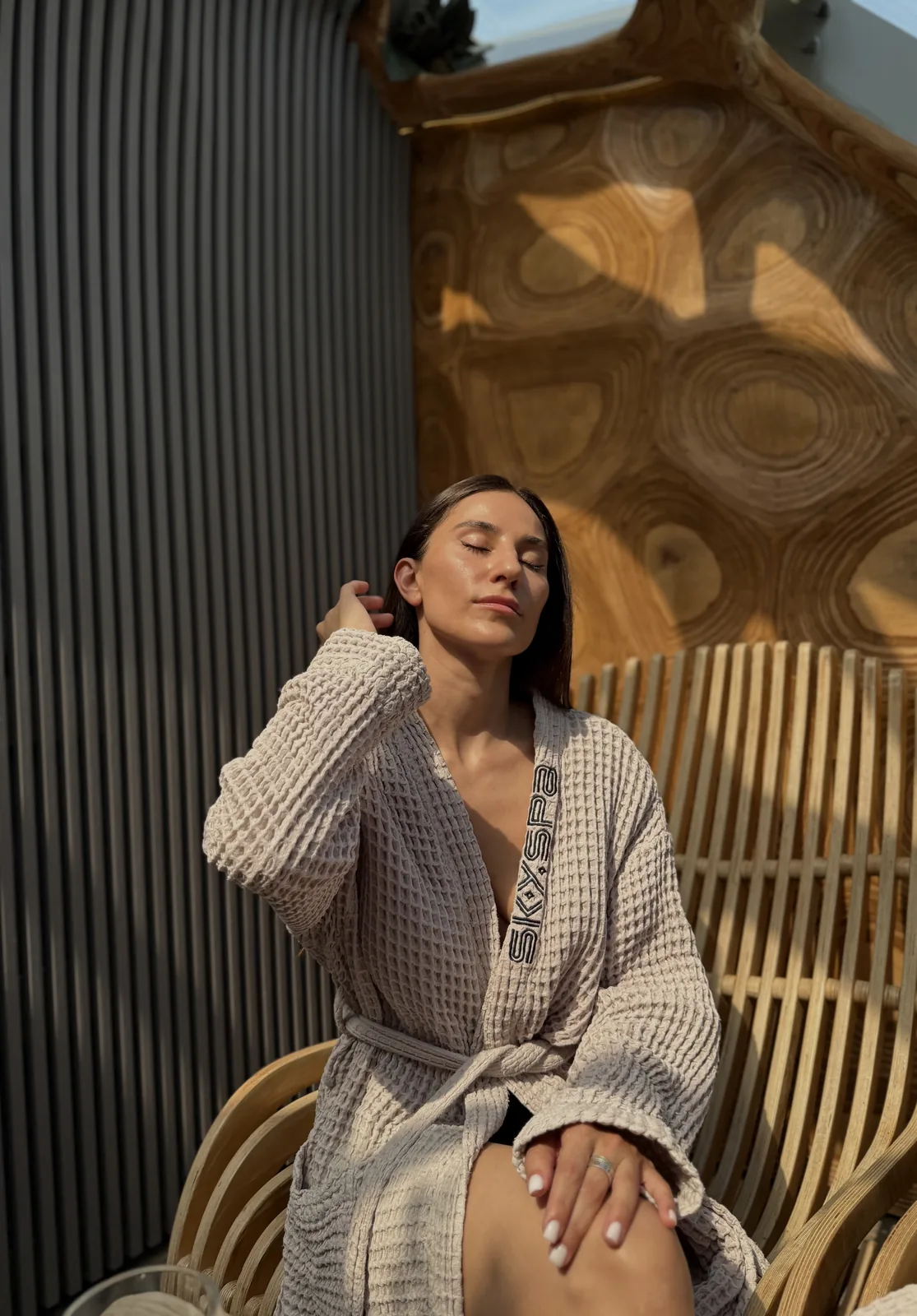 Гостья в халате SkySpa отдыхает в кресле под куполом
